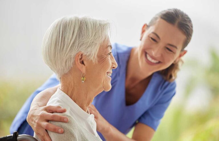Older adult and family member reviewing Medicare documents at a kitchen table beside a medication organizer.