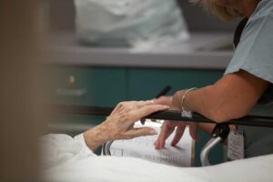 A senior sitting in a comfortably furnished apartment talking with a caregiver.